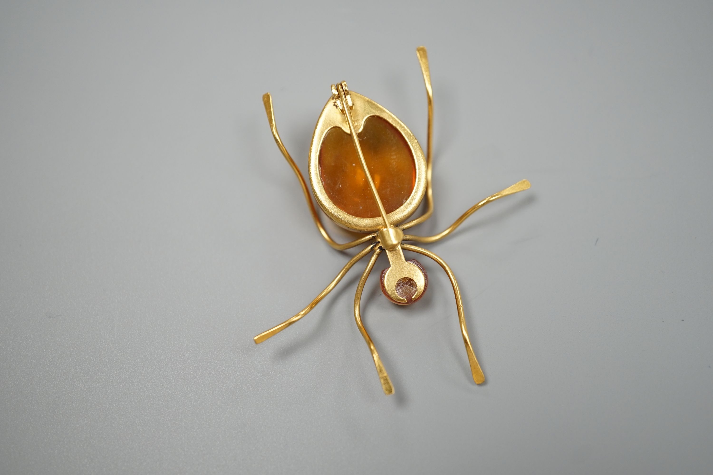 A yellow metal and two stone amber bead set bug brooch, 53mm, gross weight 5.6 grams.